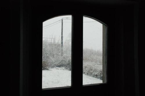 an open window with a view of a snow covered field at Monsieur Doute in Durbuy