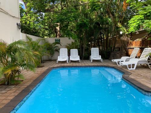 a swimming pool with lounge chairs and a swimming pool at St Lucia Palms in St Lucia