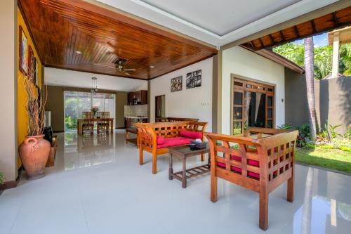 a living room with chairs and a table at Gracia Bali Villas & Apartment in Seminyak