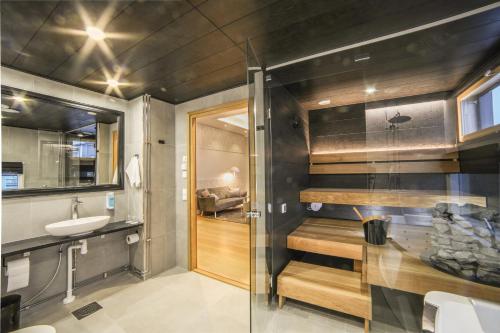 a bathroom with a shower and a sink and a toilet at Hotelli-Ravintola Alma in Seinäjoki