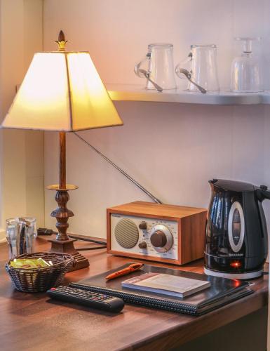 a desk with a lamp a radio and a coffee maker at Hotelli-Ravintola Alma in Seinäjoki