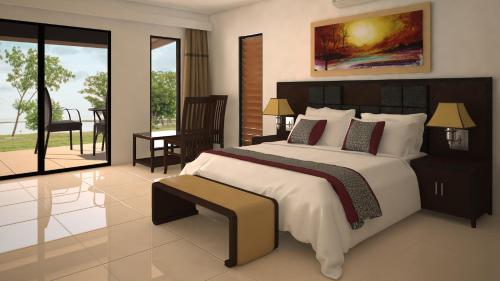 a bedroom with a large bed and a balcony at Nila Beach Resort in Lautoka