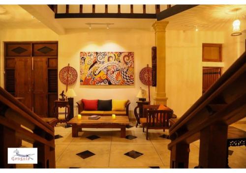 a living room with a couch and a painting on the wall at Gangula Villa in Kandy