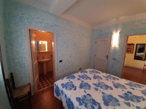 a blue bedroom with a bed and a bathroom at villamuna in Ferentillo
