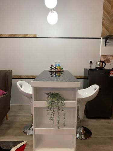 a white table with a plant on it in a room at LuxStudio Tiara Imperio in Bangi