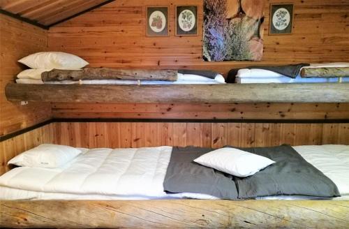 1 dormitorio con 2 camas en una cabaña de madera en Lakeland Karelia Fisherman's Paradise, en Kesälahti