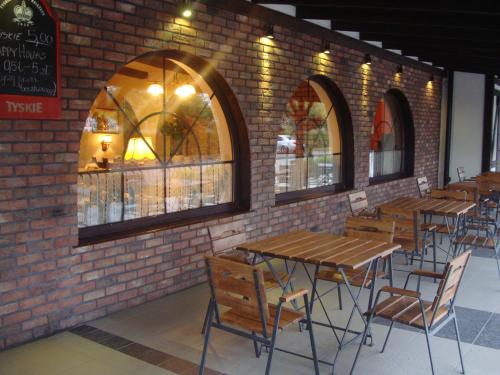 una pared de ladrillo con mesas y sillas en un restaurante en Zajazd Harasówka en Gniewkowo