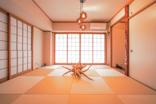 een kamer met een groot raam en een tafel op de vloer bij d3 HOTEL gallery3 in Osaka