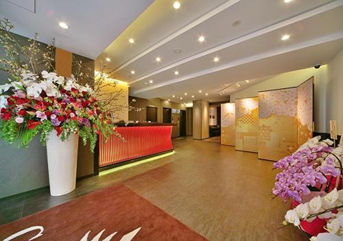 a lobby with a large vase filled with flowers at Kuromon Crystal Hotel in Osaka