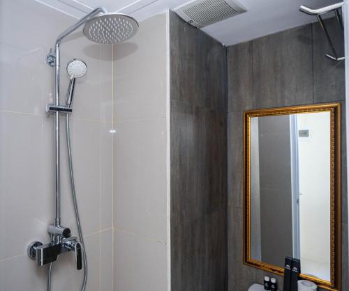 a bathroom with a shower with a mirror at Elegant Studio Apartment at Bogorienze By Travelio in Bogor