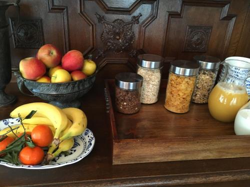 - une table avec un bol de fruits et des pots de nourriture dans l'établissement Pension Wegerich, à Erfurt