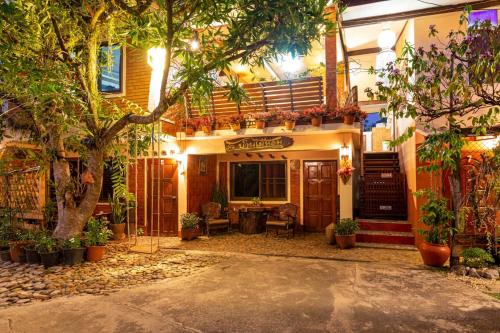 a building with trees and plants in front of it at Baan Maihorm Guesthouse in Mae Chan
