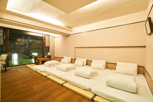 a room with four beds with white pillows at A-SAN Hot-Spring Hotel in Jiaoxi