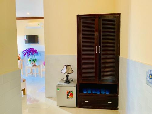 a room with a cabinet and a lamp on a table at Mekong Rose Hotel in Can Tho