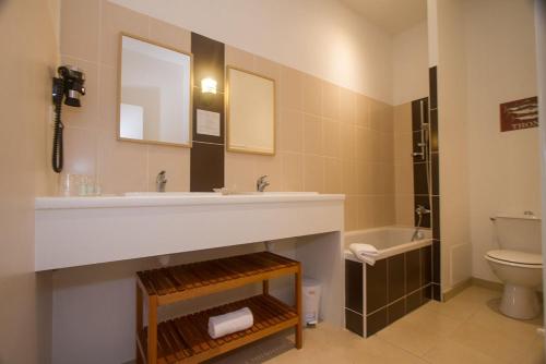 a bathroom with a sink and a toilet at Hôtel Le Vert Bois in Dolus d'Oléron