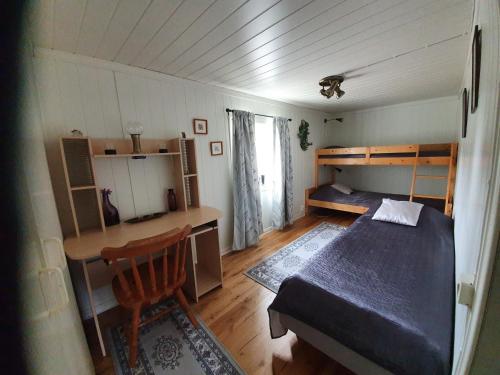 a bedroom with a bed and a desk and a table at Haga gård och Stall in Herräng