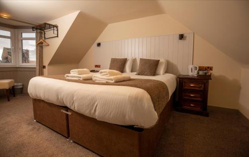 um quarto com uma cama grande e toalhas em The Whisky Vaults em Oban