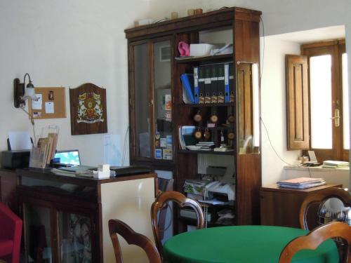 a dining room with a green table and a cabinet at Sant'Agostino Guest Rooms in Paola