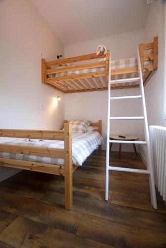 a bedroom with two bunk beds and a ladder at Hôtel Le Vert Bois in Dolus d'Oléron