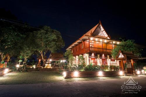 a building with lights in front of it at night at Baan Lhang Wangh บ้านหลังวัง in Phitsanulok