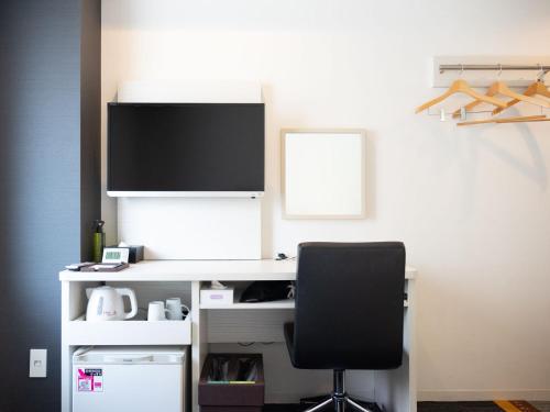 a computer desk with a monitor and a black chair at Super Hotel Shinagawa Shinbanba in Tokyo
