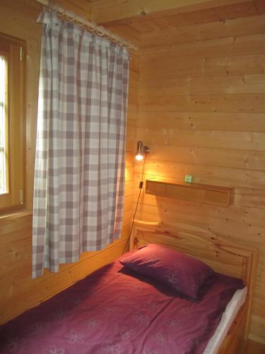 a bedroom with a bed in a log cabin at Pivarootsi Holiday Village in Pivarootsi