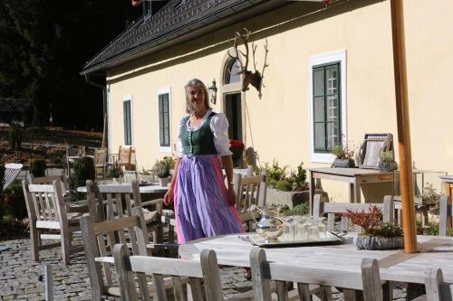 a woman in a dress standing in front of tables at Itha’s secret escape in Langschlag