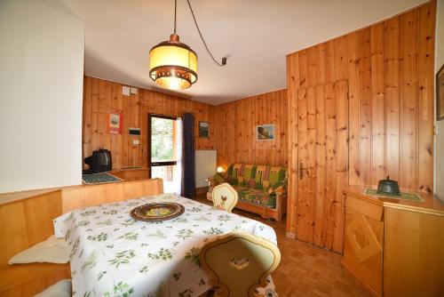 Il cirmolo في فيغو دي فاسا: غرفة نوم بجدران خشبية وسرير في غرفة