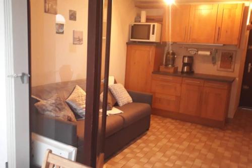 un petit salon avec un canapé et un micro-ondes dans l'établissement Appartement Le Corail, au Cap d'Agde