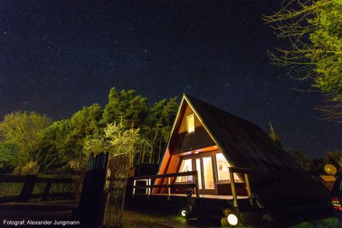 une cabine la nuit avec les étoiles dans le ciel dans l'établissement Finnhütte Rabennest, à Freest