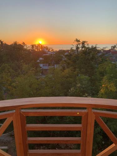 a sunset over the ocean from a wooden fence at Crown Malapascua in Malapascua Island