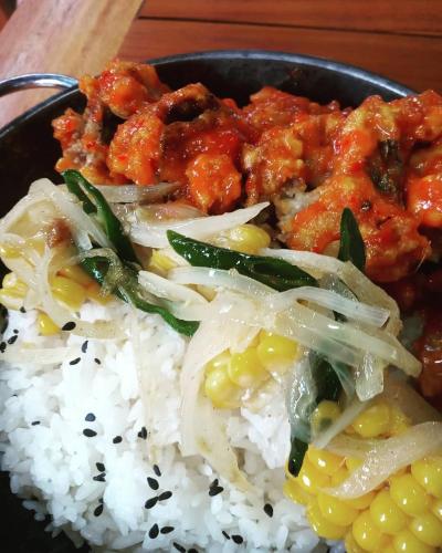 a plate of food with rice and chicken and corn at Salili Bungalow in Gili Air