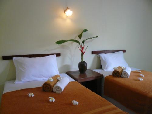 a room with two beds with towels and a plant at Baan Lamai Resort in Lamai