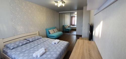 ein Schlafzimmer mit einem Bett, einem Tisch und einem Stuhl in der Unterkunft Затишна квартира з виглядом на парк in Ternopil