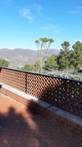 a brick fence with trees and mountains in the background at villamuna in Ferentillo