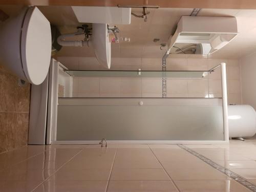 ein Bad mit einer Glastür in einem Zimmer in der Unterkunft Apartments Niko in Stinica