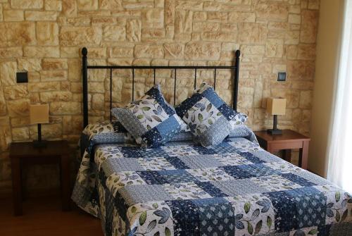 a bedroom with a bed with a blue and white quilt at Hostal del Senglar in Espluga de Francolí