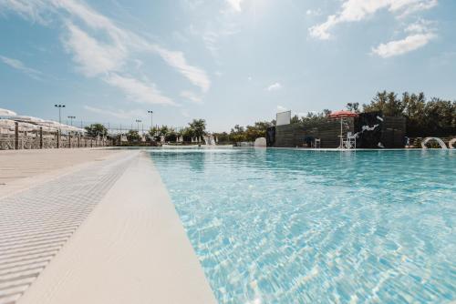 a large swimming pool with blue water at Natural Village Resort in Porto Potenza Picena