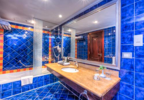 a blue tiled bathroom with a sink and a mirror at Porto Matrouh Beach Resort in Marsa Matruh
