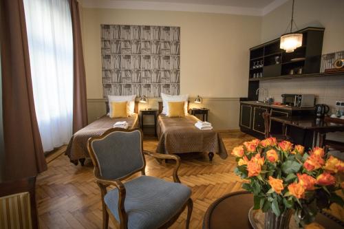 a hotel room with two beds and a vase of flowers at Scharffenberg Apartments Main Square in Krakow
