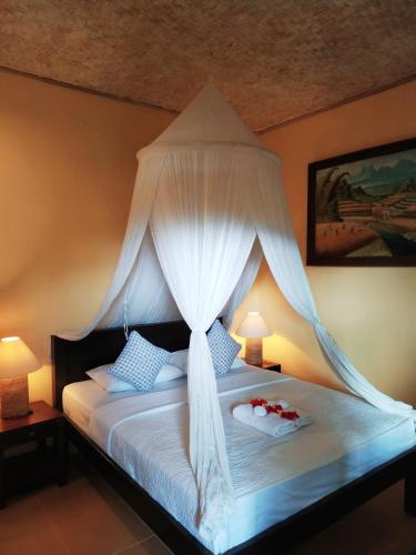 a bedroom with a bed with a canopy at Kanda Homestay in Sidemen