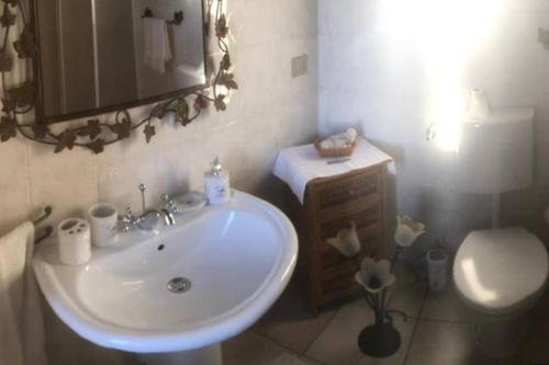 a bathroom with a white sink and a toilet at CASA MILENA in Settimo San Pietro