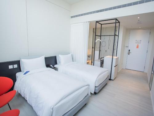a hotel room with two beds and a mirror at The Place Taichung in Taichung