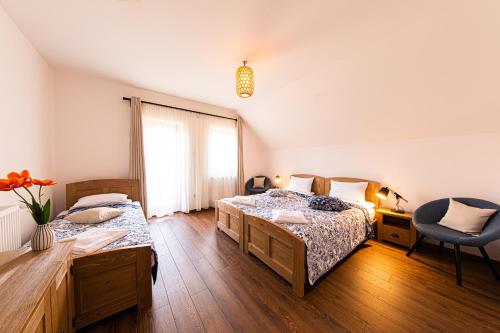 a bedroom with two beds and a desk and a chair at Hygge Praid in Praid