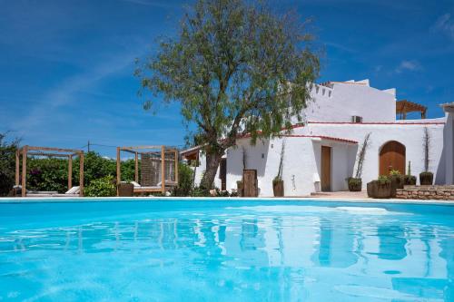 uma villa com piscina em frente a uma casa em La Masía de Formentera em Sant Francesc Xavier
