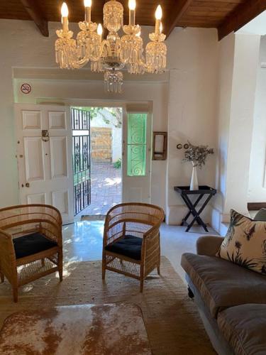a living room with a couch and chairs and a chandelier at The Prime Spot Self Catering in Worcester