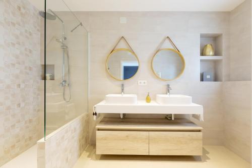 a bathroom with two sinks and two mirrors at Huerta in San Antonio