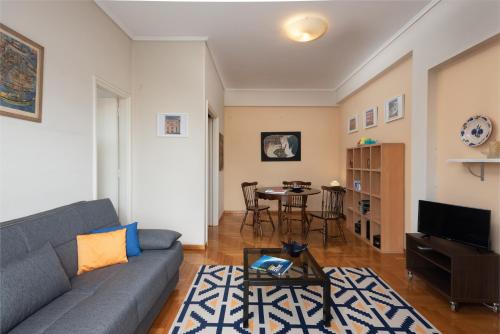 a living room with a couch and a table at So Athens - Charming 1BD flat, Large terrace, Acropolis view in Athens