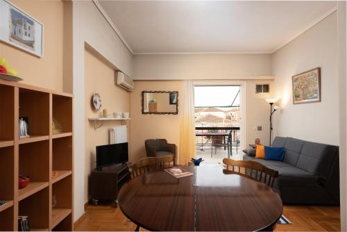 アテネにあるSo Athens - Charming 1BD flat, Large terrace, Acropolis viewのテーブルとソファのあるリビングルーム