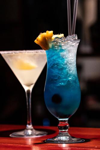 a blue drink and a martini on a table at Gooderson Drakensberg Gardens Golf & Spa Resort in Drakensberg Garden